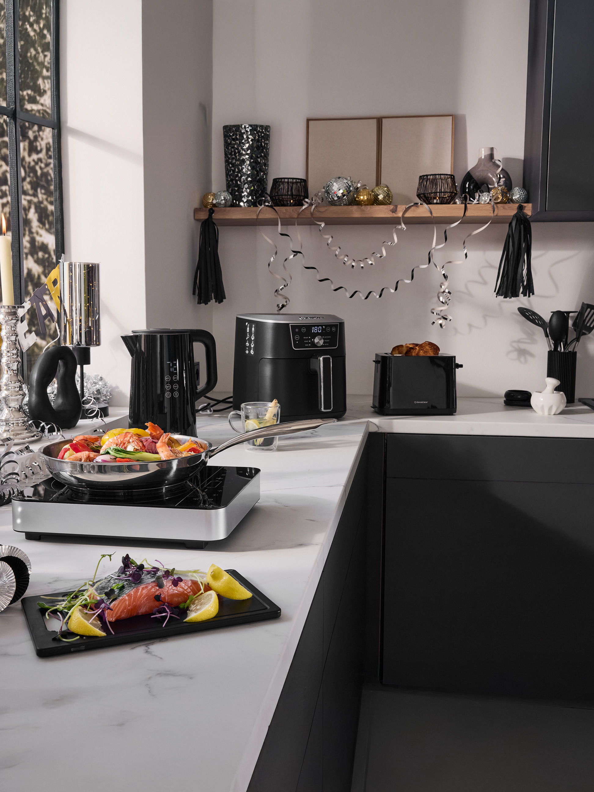Kuchynská linka s teplovzdušnou fritézou SilverCrest, rýchlovarnou kanvicou, hriankovačom a kuchynským náradím, slávnostne vyzdobená.
