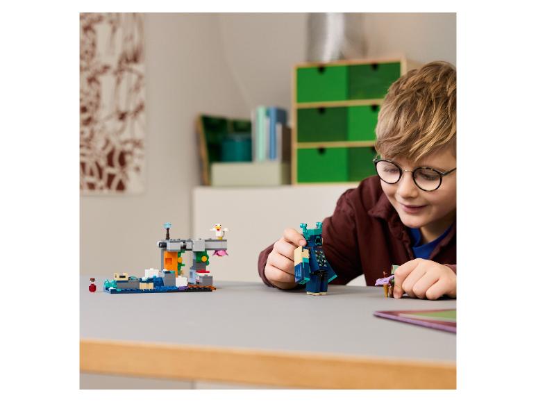 Chlapec sa hrá s LEGO Minecraft súpravou s figúrkou Wardena a malou stavbou.