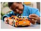 Dieťa skladá oranžové auto LEGO Technic Fast & Furious.