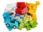 Kopa farebných kociek LEGO DUPLO s dvoma figúrkami a autom.