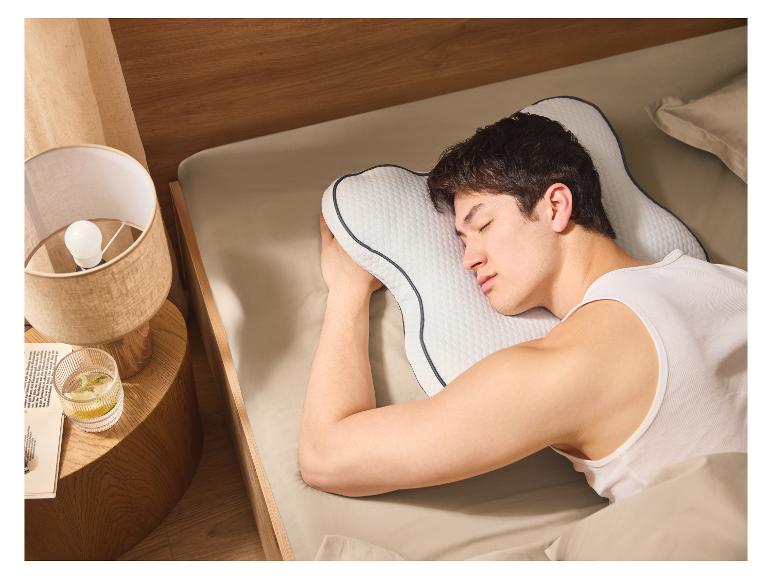 Muž pokojne spí na ergonomickom vankúši.