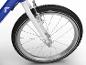 Detail predného kolesa modro-bieleho detského bicykla s dezénom pneumatiky.
