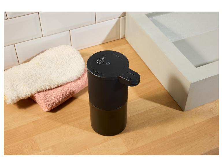 Čierny automatický dávkovač mydla Livarno Home na drevenom pulte.