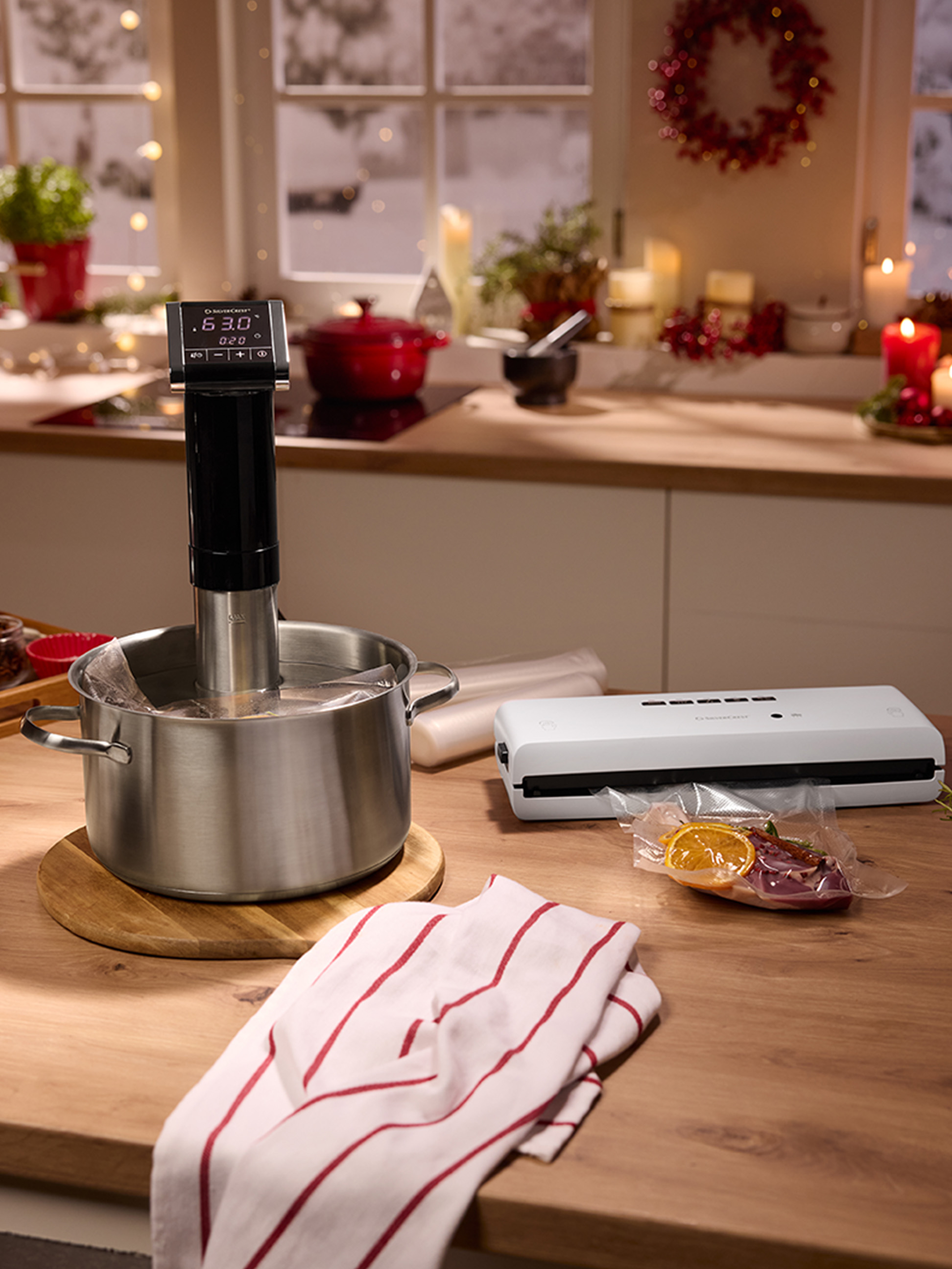 Sous vide varič a vákuovačka na kuchynskej linke s vianočnými dekoráciami.