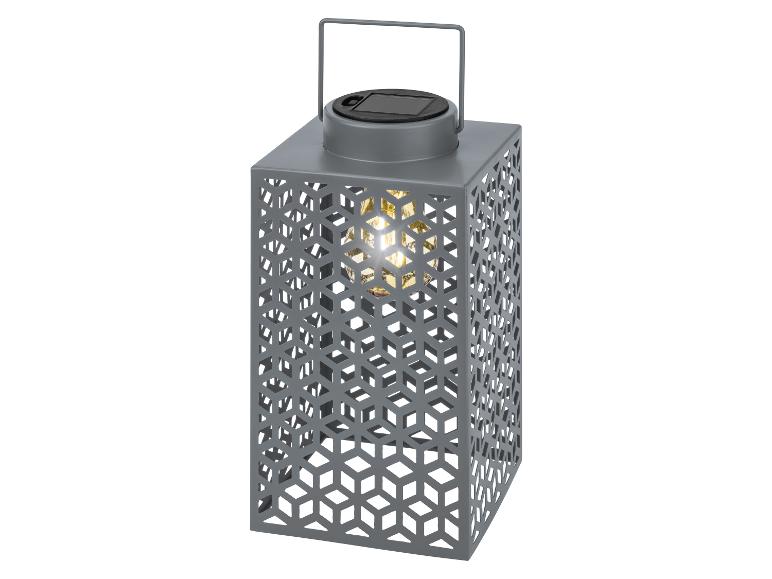 Sivý solárny lampáš s geometrickým dizajnom a teplým svetlom.