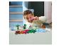 Dieťa sa hrá s LEGO DUPLO dinosaurími a sopečnými kockami na stole.