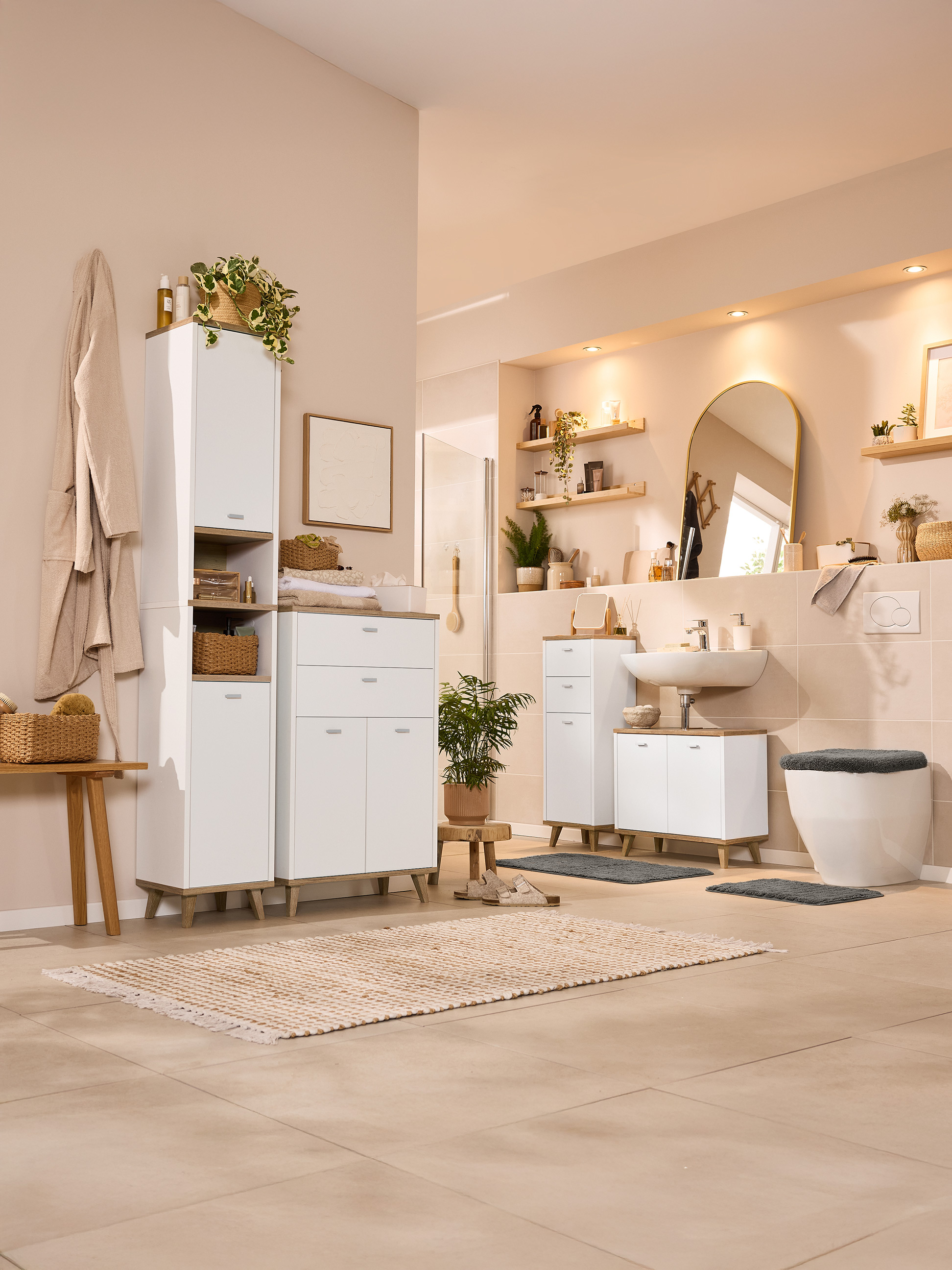 Svetlá kúpeľňa s bielym nábytkom, drevenými akcentmi a rastlinami.