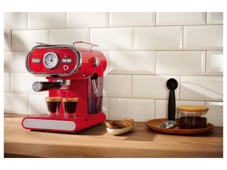 Červený retro kávovar na espresso pripravuje kávu na drevenej doske.