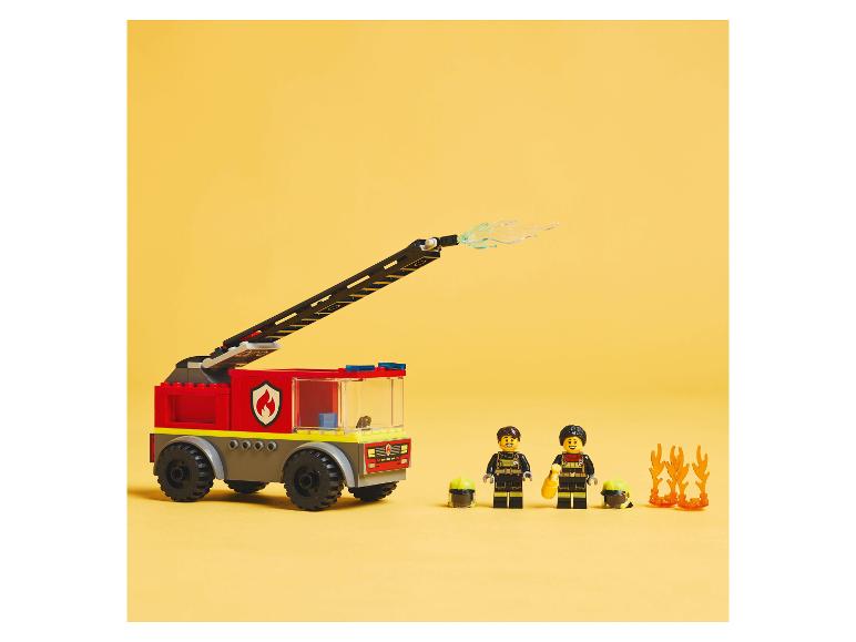 LEGO hasičské auto a minifigúrky s príslušenstvom na žltom pozadí.