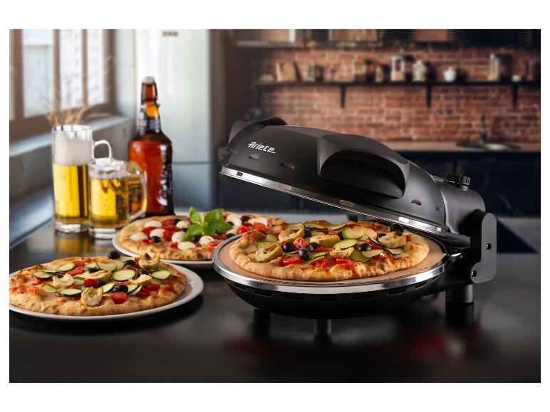 Pizza v pizza peci, dve pizze na tanieroch a pivo na stole.