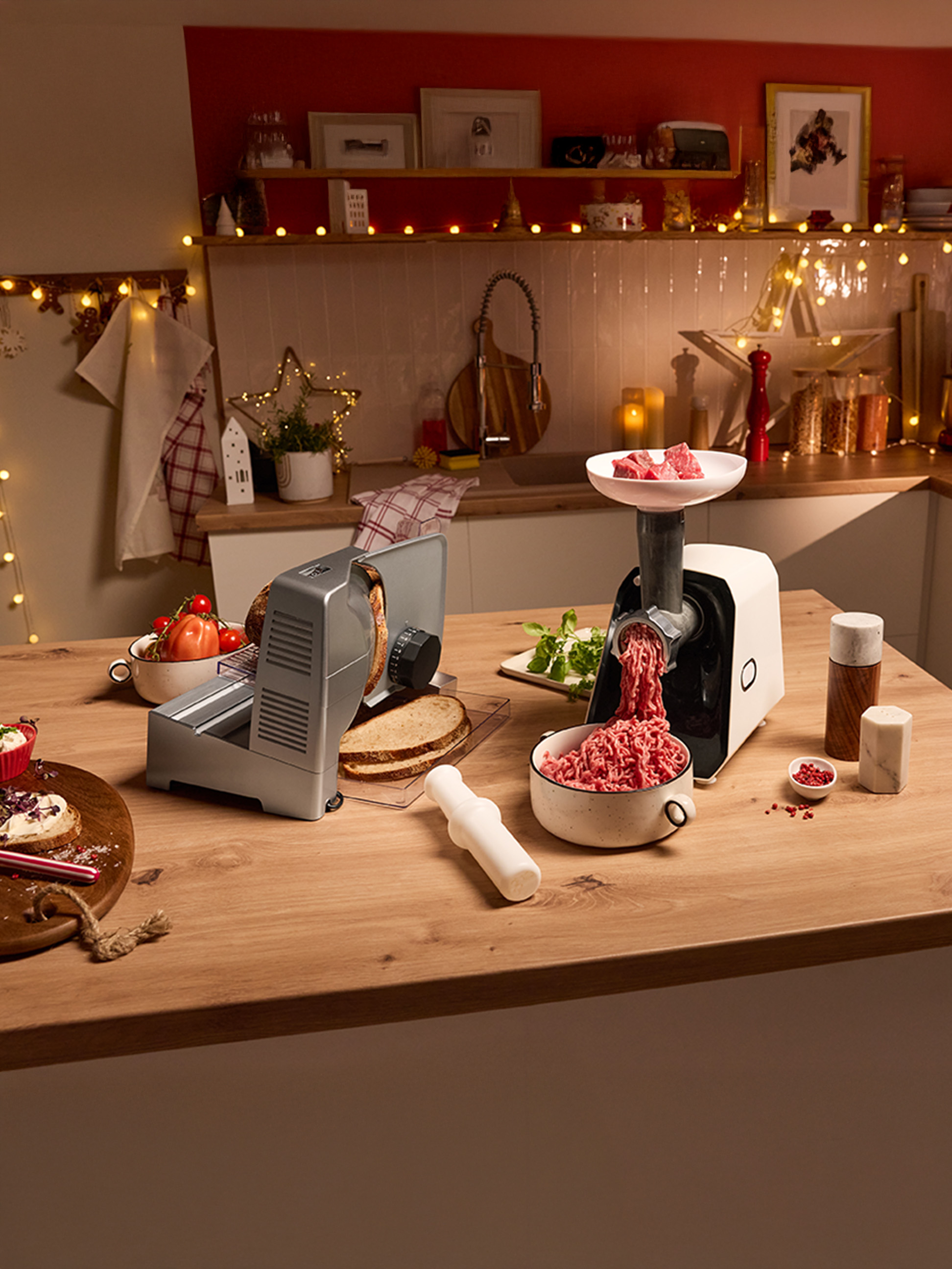 Mlynček na mäso a krájač chleba na sviatočne vyzdobenej kuchynskej linke.