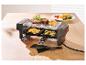 Raclette gril so steakom, zemiakmi a cuketou na drevenom stole.