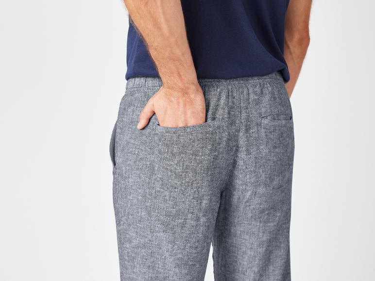 Sivé ľanové nohavice a tmavomodré tričko.