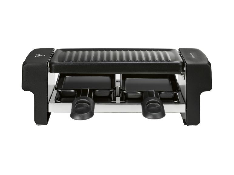 Čierny raclette gril s dvoma panvicami a rebrovanou hornou doskou.