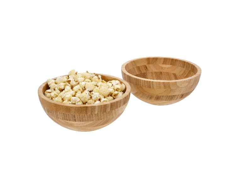 Dve drevené misky, jedna plná popcornu, druhá prázdna.