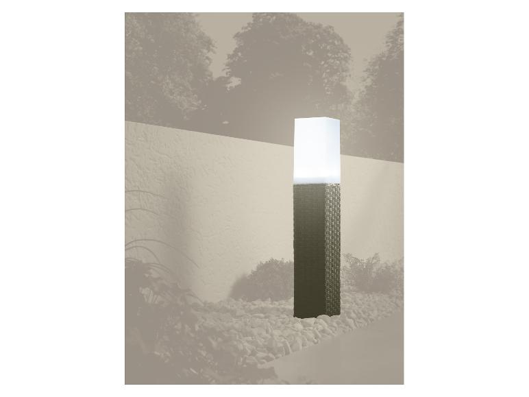 Záhradná lampa s pleteným podstavcom a bielym tienidlom, obklopená kamienkami.