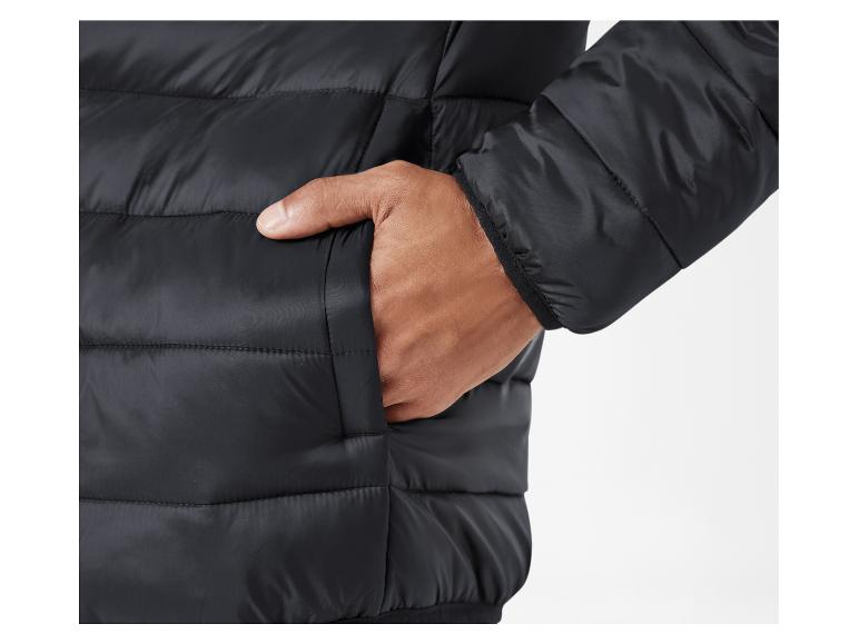 Detailný pohľad na čiernu páperovú bundu s rukou vo vrecku.
