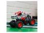 Sivý a červený monster truck LEGO Technic Thunder Roarus na zelených knihách.