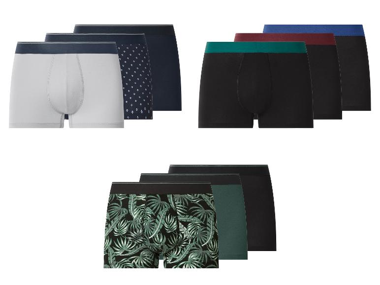 Pánske boxerky v rôznych farbách a vzoroch, vrátane bielych, čiernych, s geometrickými a listovými potlačami.