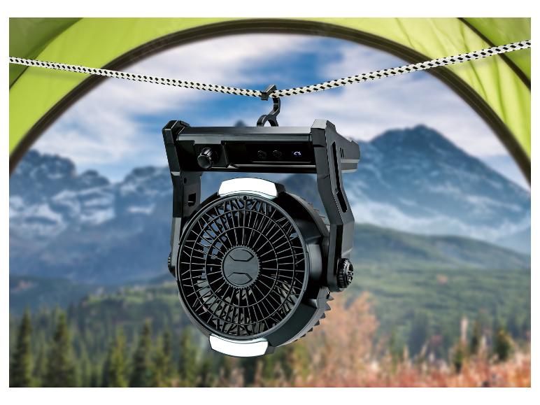 Kempingový ventilátor s LED svetlom zavesený v stane, s výhľadom na hory.