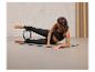 Žena cvičí pilates s kruhom na podložke.