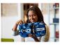 Žena drží modrý model auta LEGO Technic Ford GT s bielymi pruhmi.