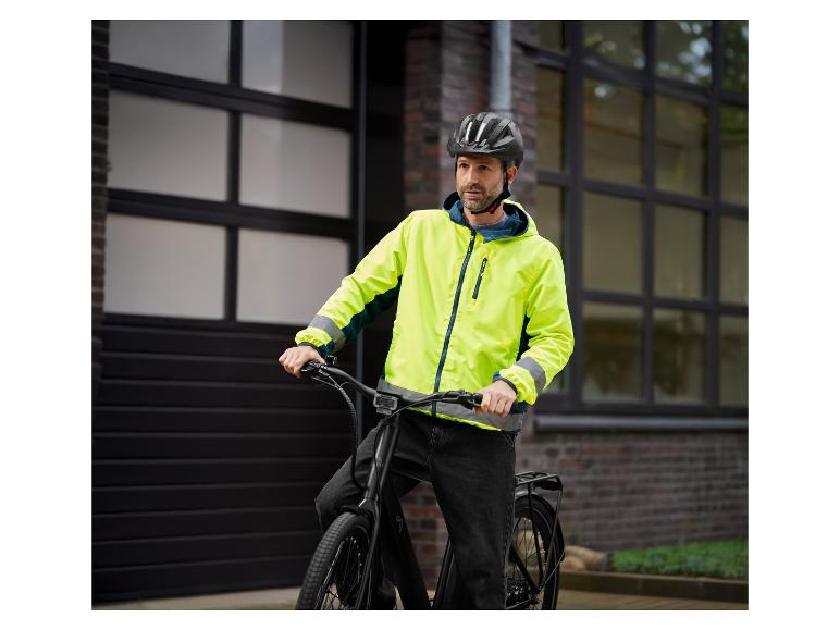 Muž na čiernom bicykli v žltej vetrovke