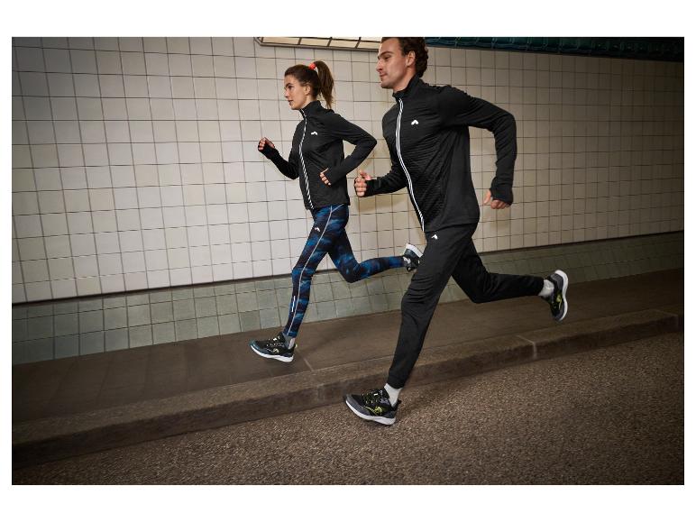 Dvaja bežci v čiernom a modrom športovom oblečení, v tuneli.