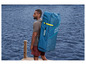 Muž nesie na chrbte nafukovací paddleboard Hydro-Force.
