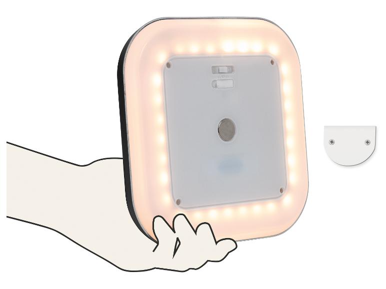 Štvorcová LED lampa s teplým bielym svetlom, držaná v ruke, s montážnou konzolou vedľa nej.
