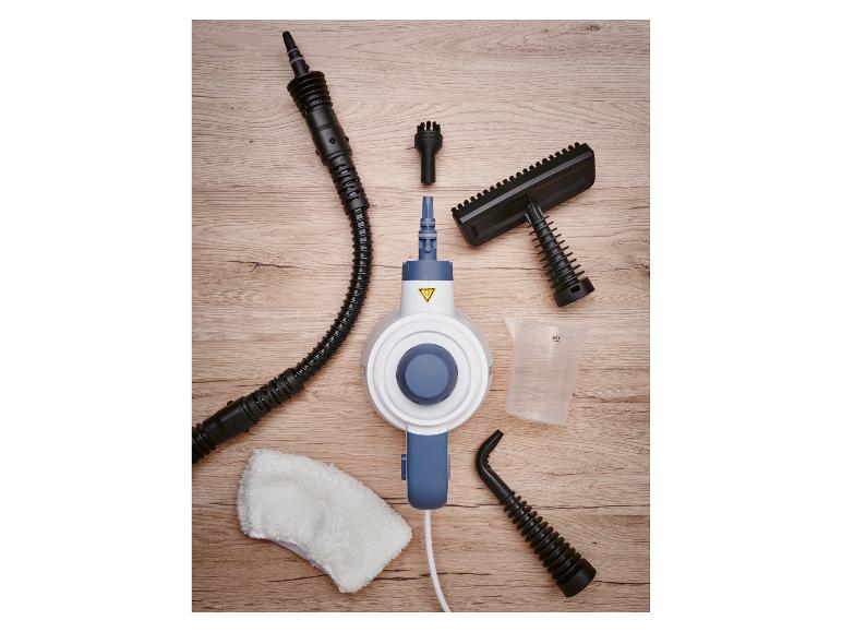 Ručný parný čistič s rôznymi tryskami, odmerkou a čistiacou handričkou na drevenom povrchu.