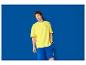 Muž v žltom tričku a modrých šortkách s logom Lidl.