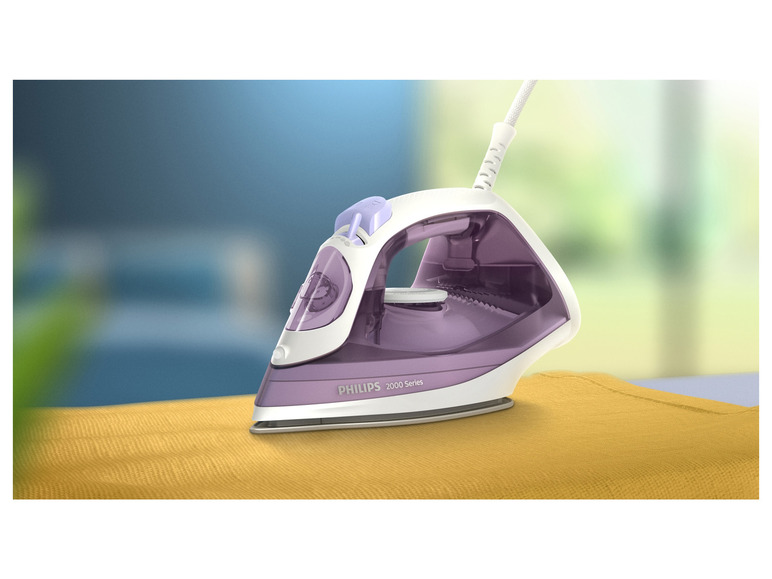 Fialová žehlička Philips 2000 Series na žltej látke.