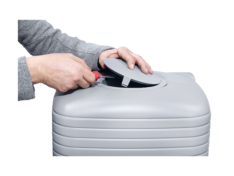 Osoba otvára veko šedej nádrže na vodu.