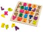 Drevené puzzle s farebnými písmenami abecedy, niektoré mimo dosky.