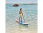 Muž pádluje na nafukovacím paddleboarde v mori.