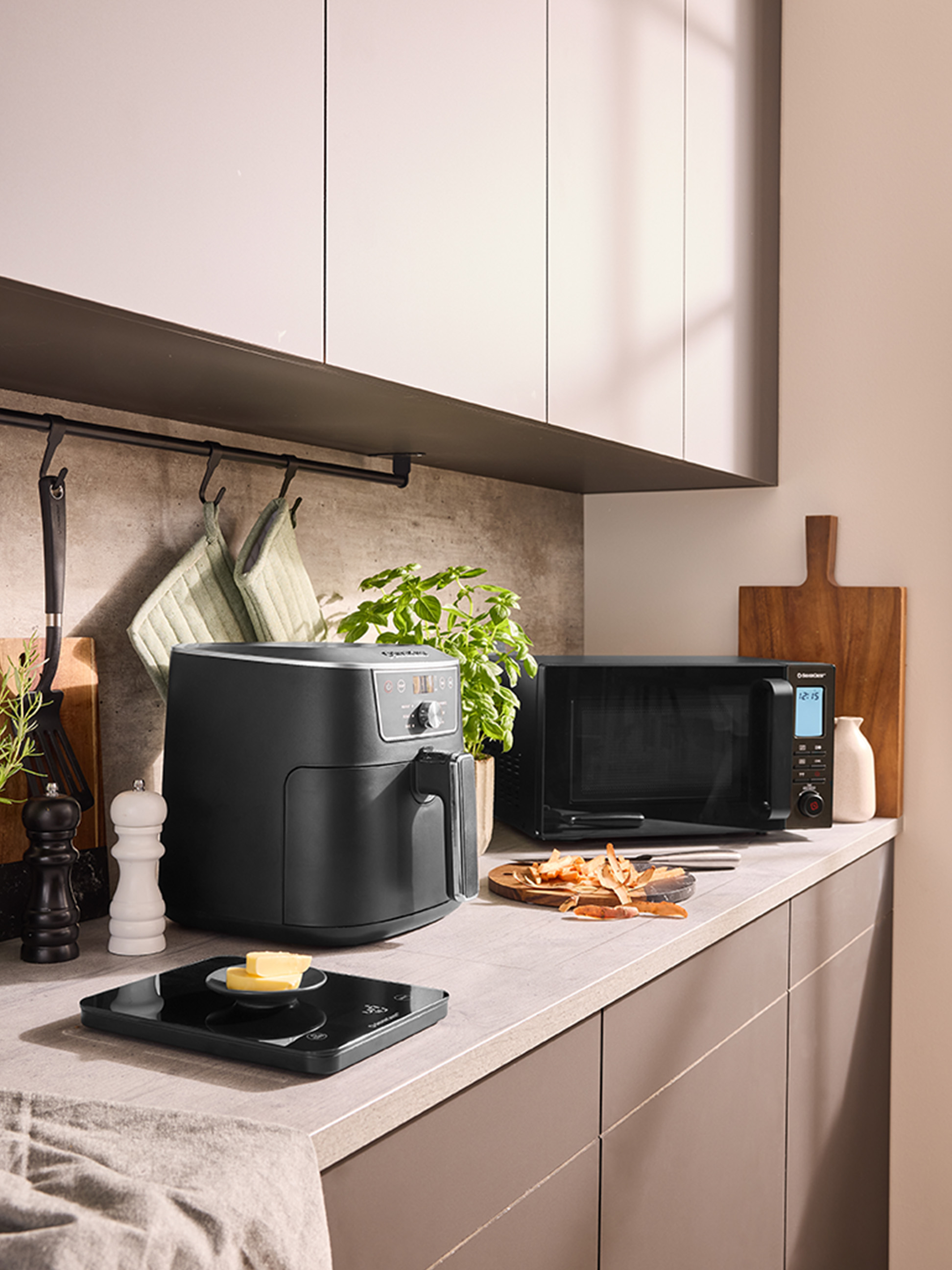 Teplovzdušná fritéza a mikrovlnná rúra na modernej kuchynskej linke.