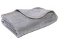 Sivá, mäkká deka z fleecovej tkaniny zložená.