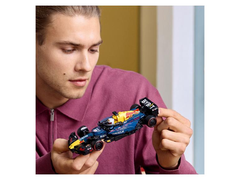 Muž drží v rukách Lego Red Bull Racing formulu 1.