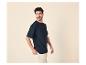 Muž v tmavomodrom tričku a béžových nohaviciach, pozerajúci sa do strany.