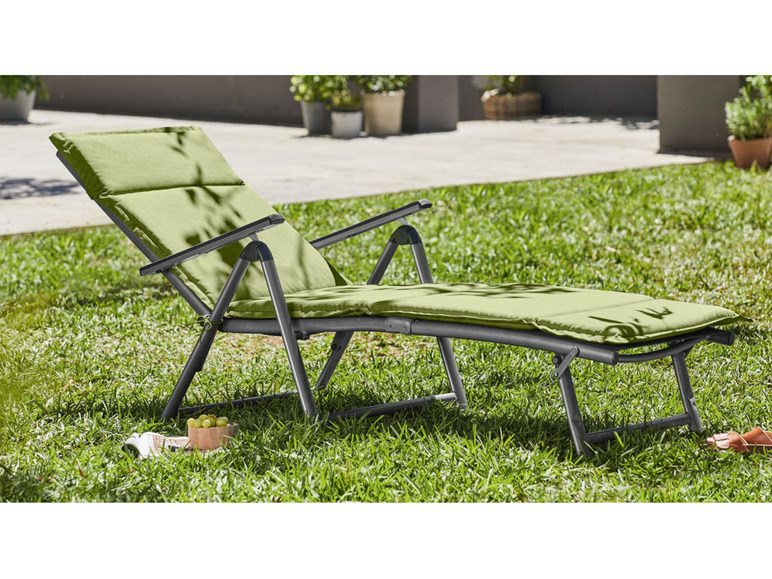 Lehátko s opierkami na tráve v záhrade.