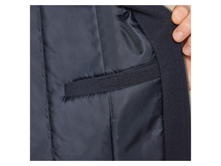 Vnútorná strana tmavomodrej bundy so zipsom a vreckom.