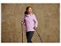 Žena v ružovej vetrovke s palicami na nordic walking.