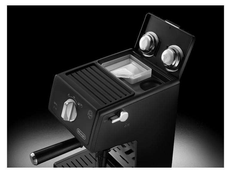 Čierny kávovar De'Longhi so striebornými gombíkmi a príslušenstvom.