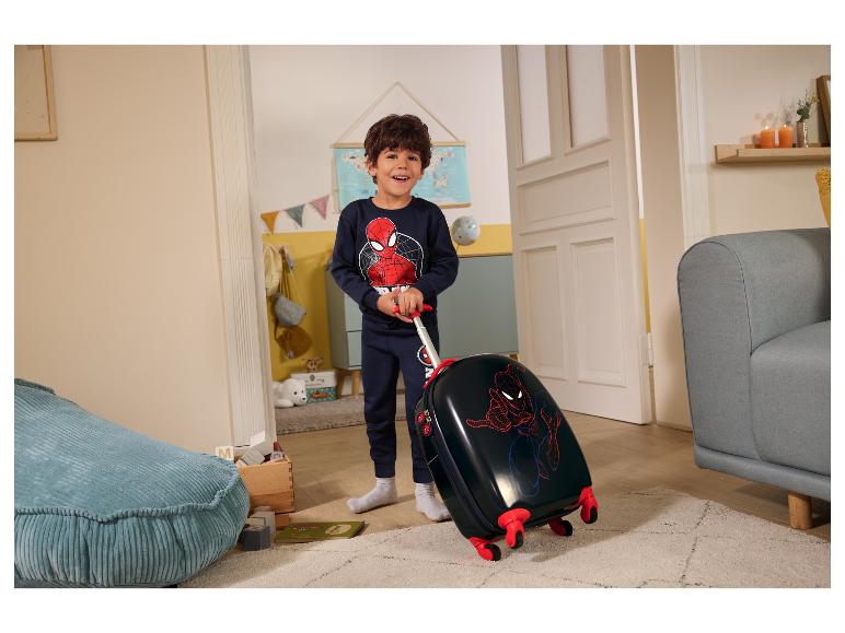 Šťastný chlapec v pyžame Spider-Man ťahá čierny kufor Spider-Man.