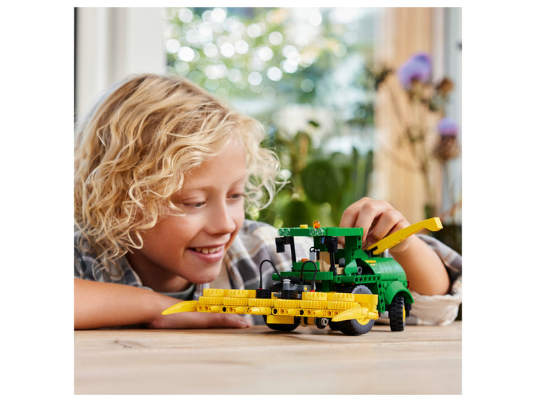 Dieťa sa hrá s LEGO John Deere žací stroj.