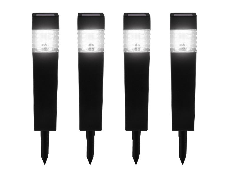 Štyri čierne solárne záhradné svietidlá s bielym svetlom a hrotmi do zeme.