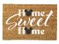 Hnedá rohožka s nápisom „Home Sweet Home“ a čiernymi myšími hlavami.
