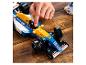 Ruka osoby nastavuje modro-žltý model pretekárskeho auta Lego Williams Formula 1.