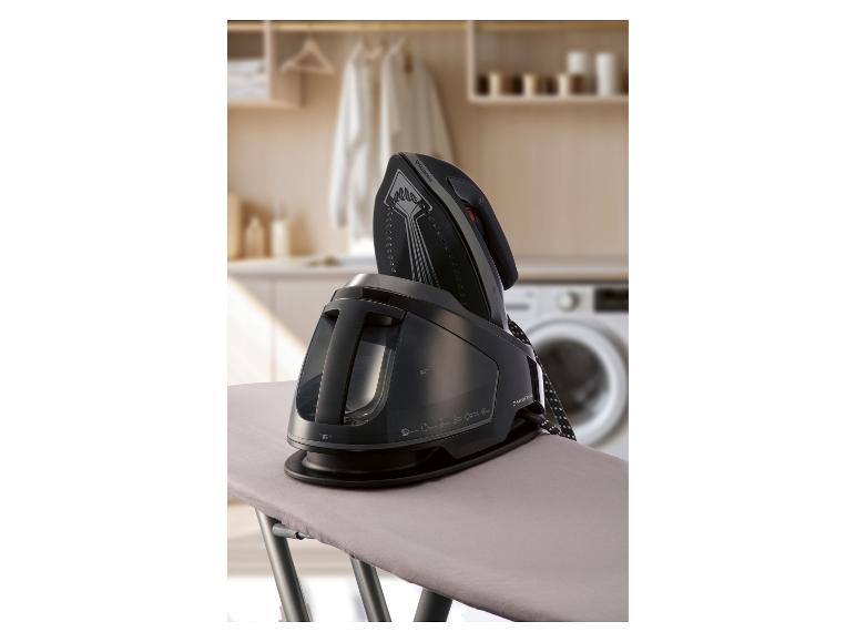 Parná žehlička na žehliacej doske v práčovni.